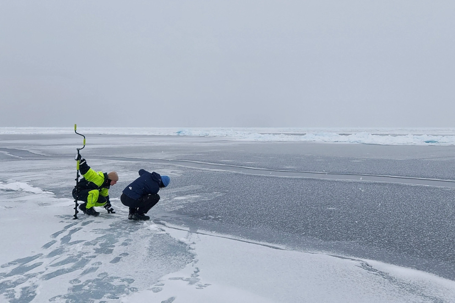 Vinterens haviskant i Diskobukta i mars 2023. Doktorgradsstudent Linda Latuta og masterstudent Dana King leter etter et trygt sted å ta temperatur- og saltinnholdsobservasjoner fra fastisen, havisen som er festet til land og grunnstøtte isfjell. Foto Lars H. Smedsrud (Universitetet i Bergen).